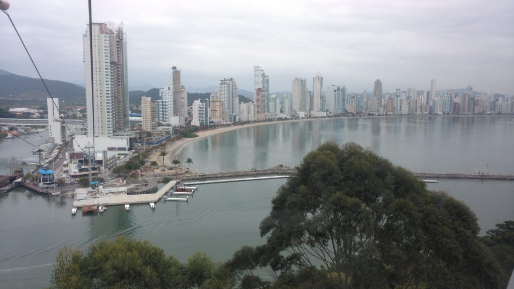 Vista aérea da cidade com prédios e mar a volta Conheça Balneário Camboriú