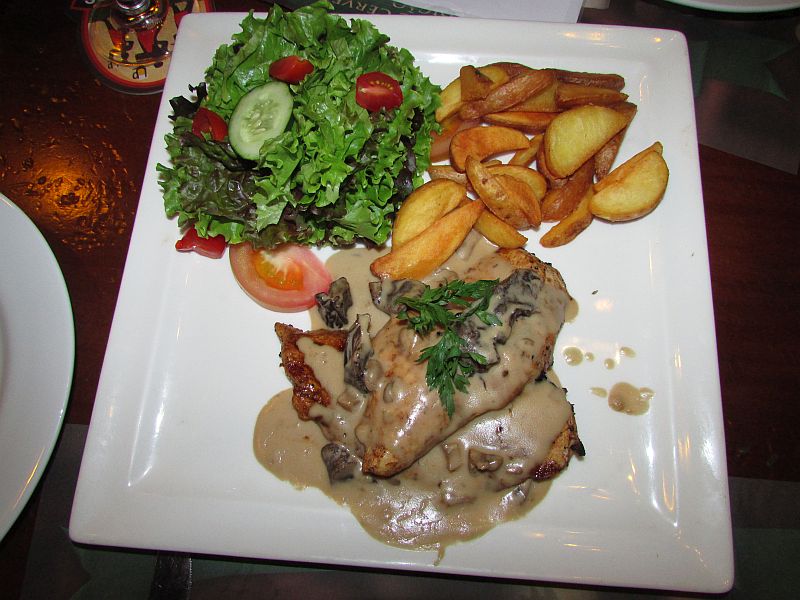 escalope de frango ao molho de cogumelos dentro de um prato branco brewpub francês