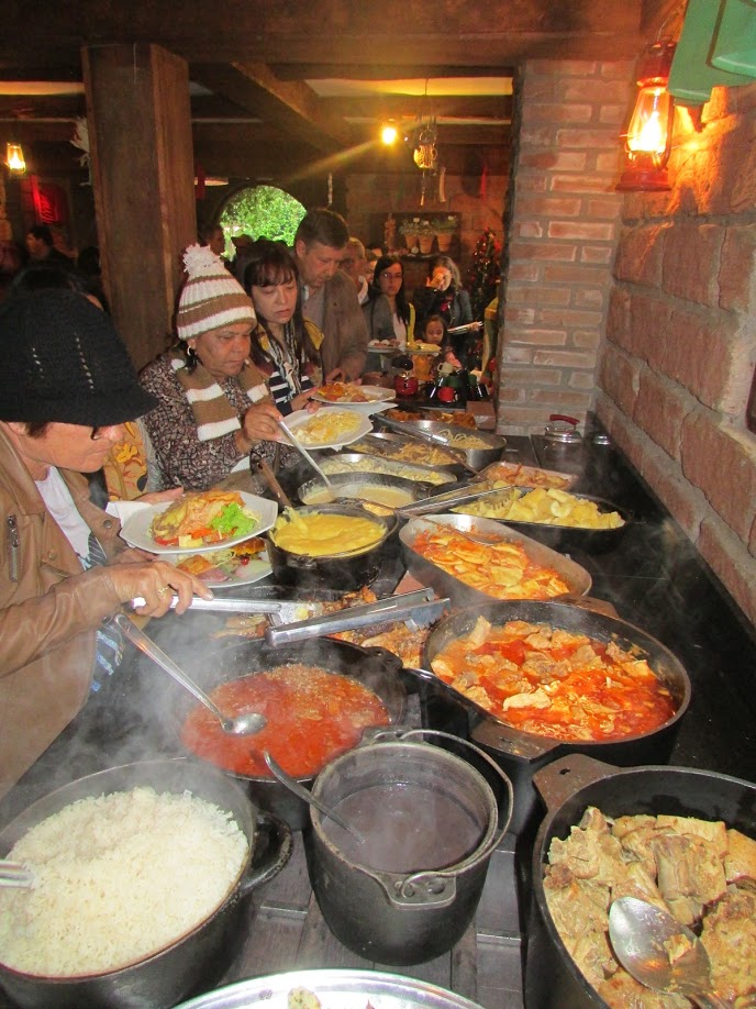 Fila de pessoas servindo-se em bufê Onde comer em Gramado