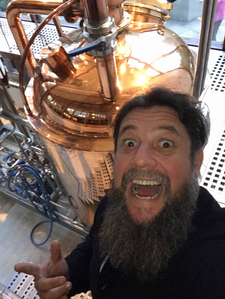 Homem com barba em frente a aparelho metalico