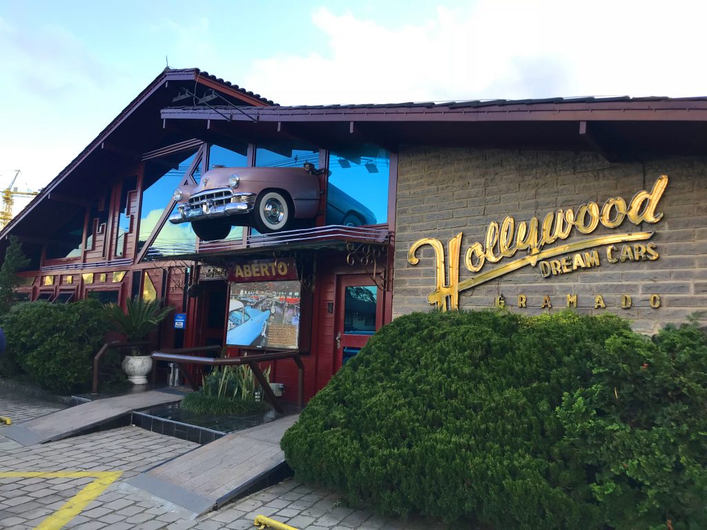 Fachada de museu automotivo com réplica de carro atravessando vidraça Carros antigos em Gramado