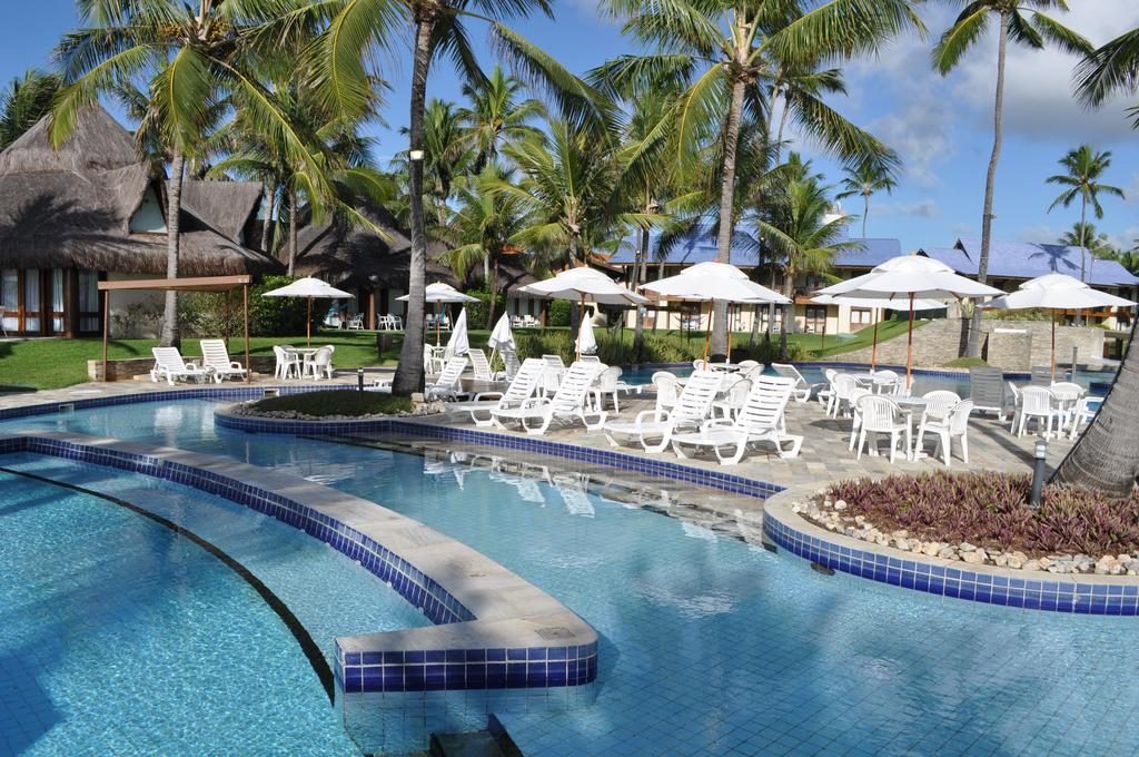 Área da piscina do resort com cadeiras de sol Hotéis e resorts para Natal e Réveillon