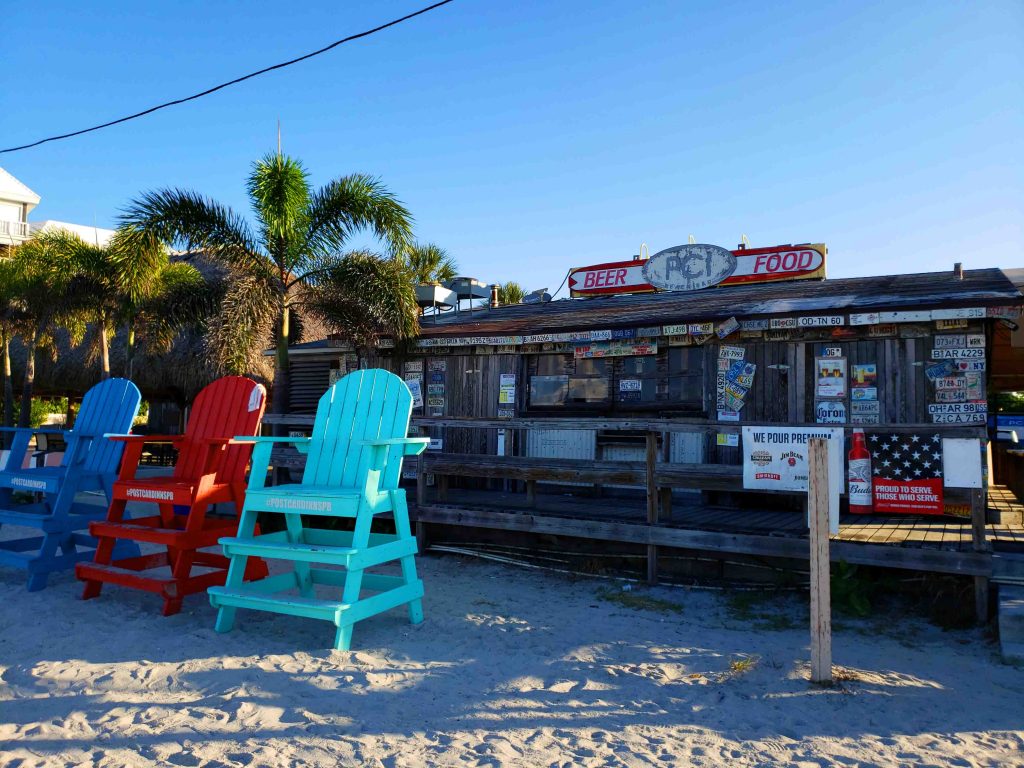 Imagem de uma lojinha na praia com cadeiras para observar o mar Hotéis em St. Pete & Clearwater
