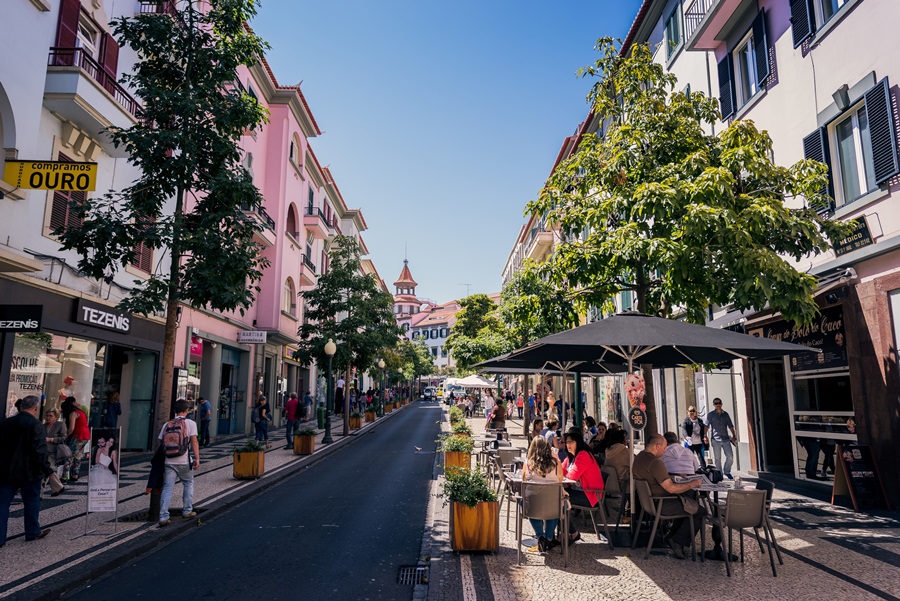 rua colorida com centros comerciais e cadeiras espalhadas