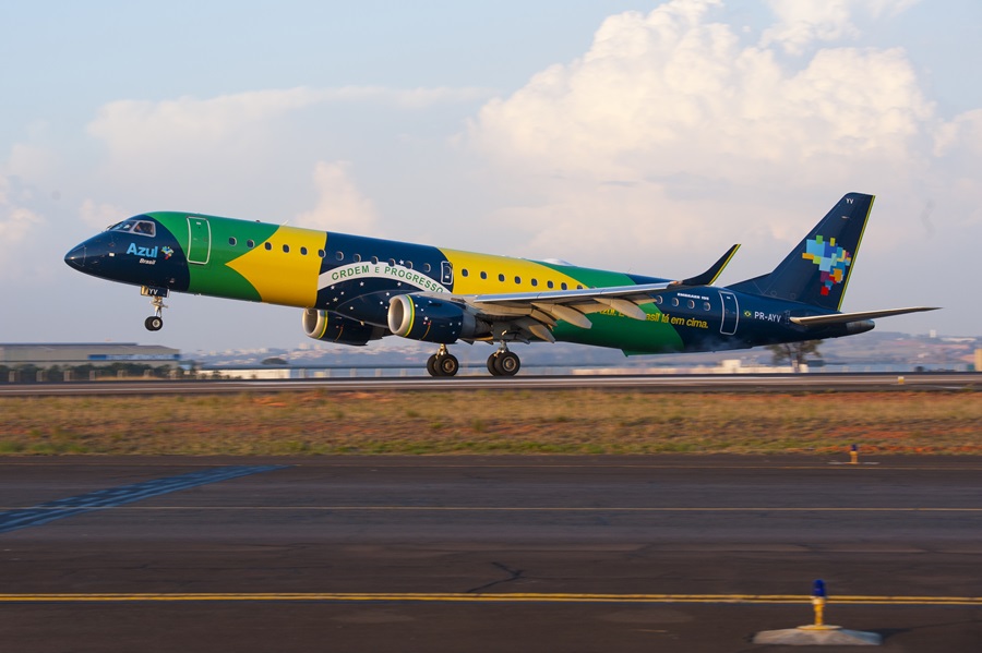 Aeronave estampada com a bandeira do brasil saindo do solo Azul; Salvador e Maceió