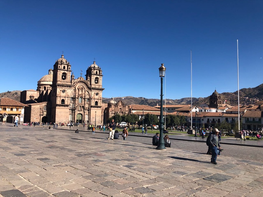 Uma praça em Cusco com pessoas caminhando pela calçada Peru; roteiro no Peru