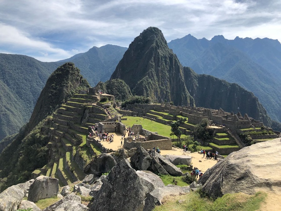 montanhas e pedras cobertas de verde com pessoas caminhando para apreciar a vista do alto Peru; roteiro no Peru