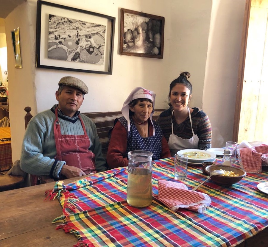 três pessoas sentadas de frente para a mesa onde está servido o almoço típico peruano e pisco com uma toalha colorida estendida Peru; roteiro no Peru