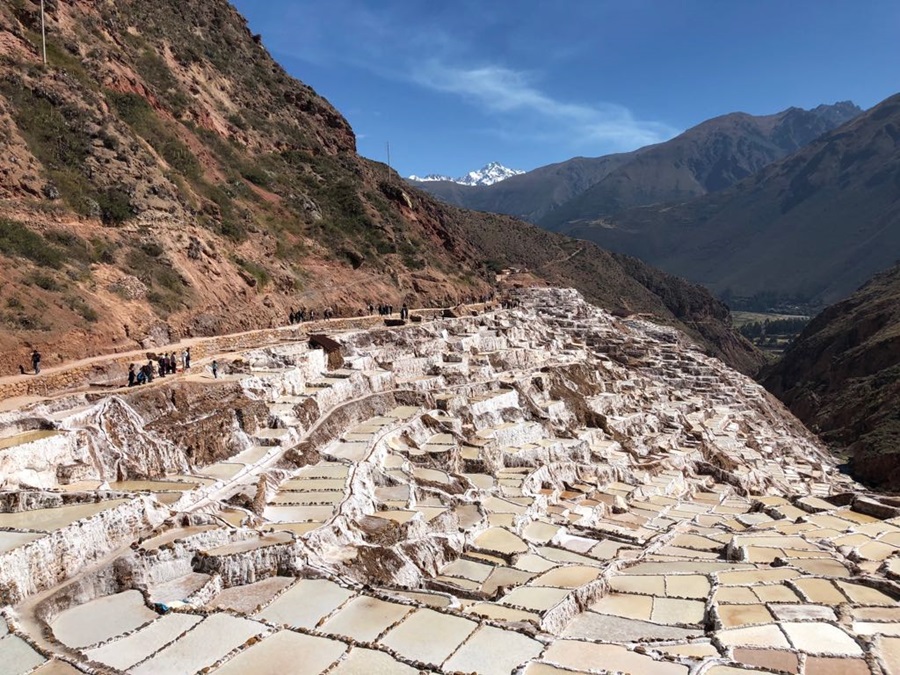 montanhas e arvores em volta das salinas de maras e algumas pessoas apreciando a vista Peru; roteiro no Peru