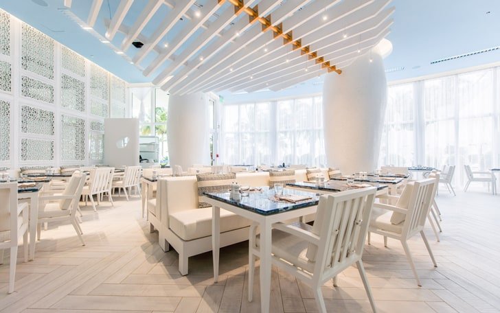 Interior de um restaurante com madeiras e decoração na cor branca Miami Spice; Bal Harbour