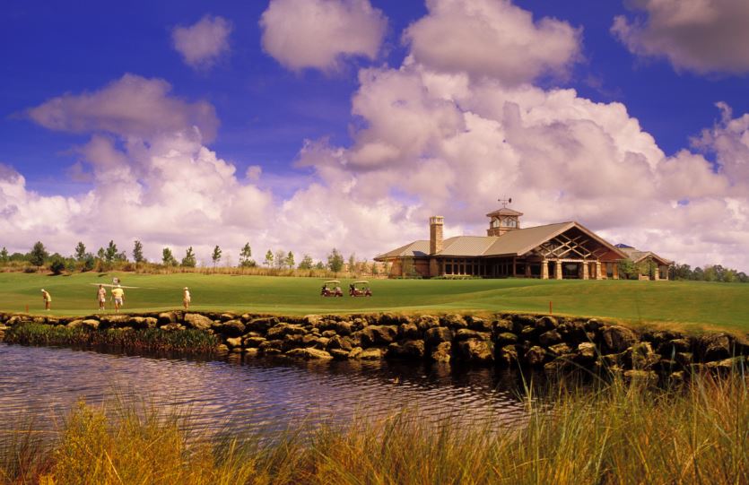 fazenda com campo de golfe e um lago com pessoas ao fundo praticando o esporte Golfe na Flórida