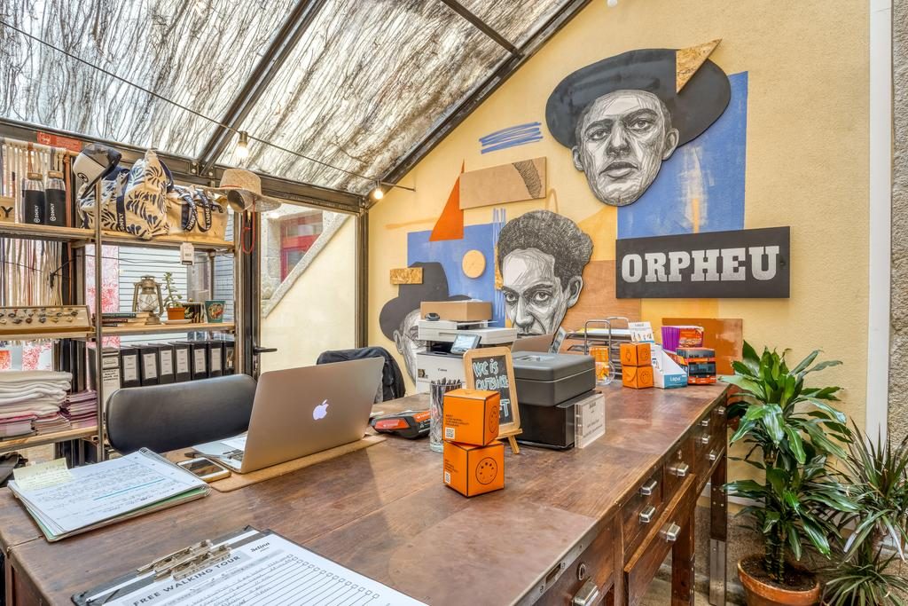 área do hotel para trabalhar com mesa, computador, papéis, objetos de decoração Selina Cidade do Porto