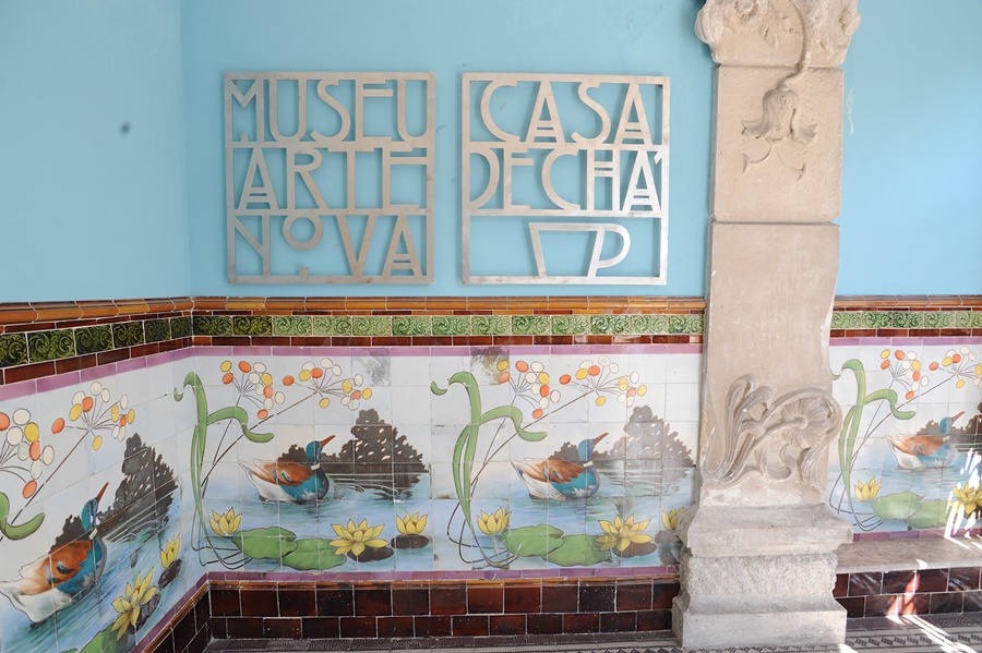 Parede do museu de arte nova em portugal com azulejos coloridos com desenho na parede e uma coluna desenhada Centro de Portugal Arte