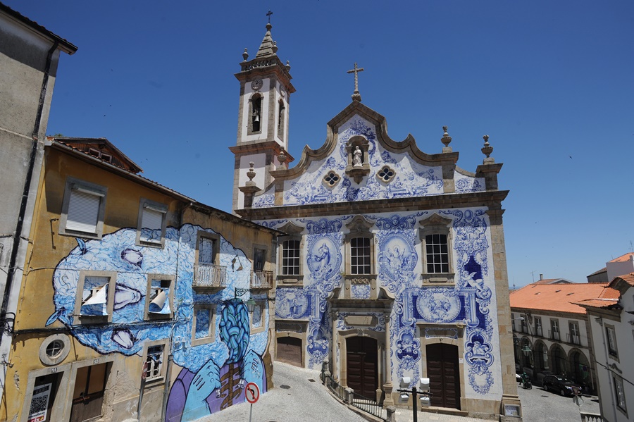 Igreja Santa Maria Maior em Covilhã com azulejos azuis e grafites coloridos ao lado Centro de Portugal