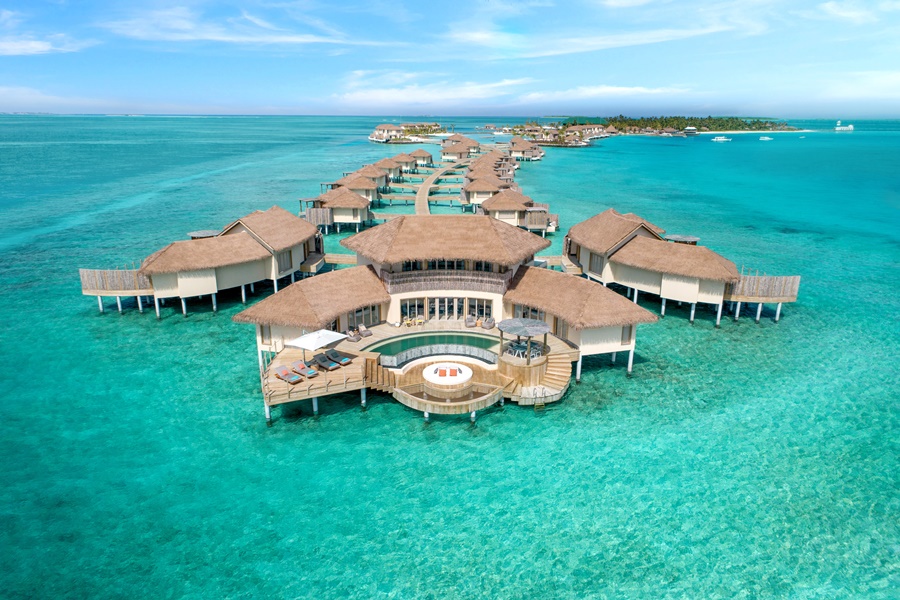 Vista aérea do complexo de residências de três quartos com o mar de cor clara em volta InterContinental Maldives Maamunagau