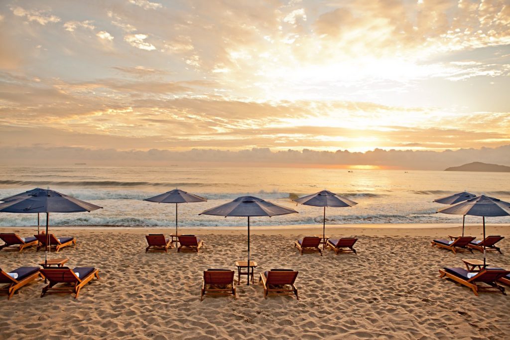 praia com cadeiras e guarda sóis abertos Infinity Blue
