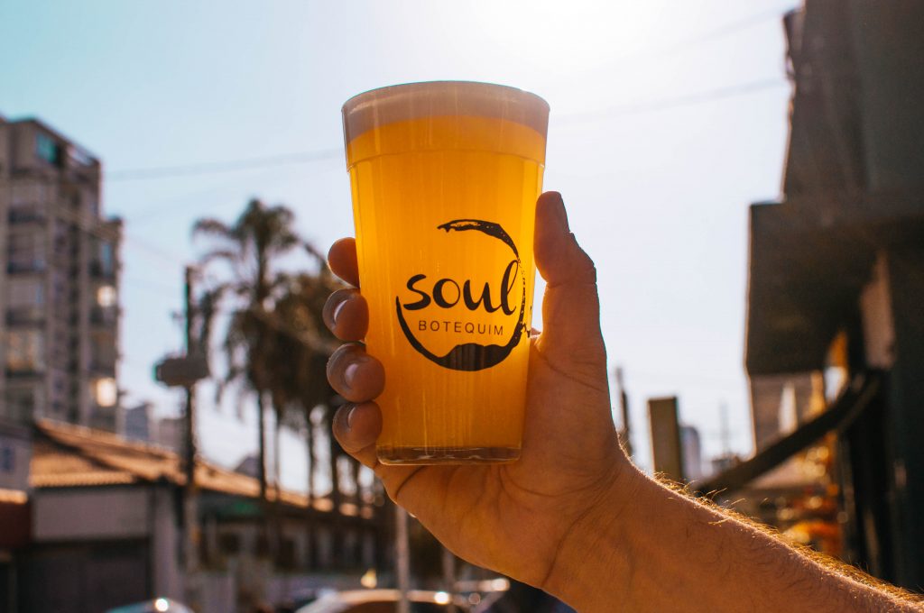 pessoa segurando um copo com cerveja da marca soul botequim bares em São Paulo NFL