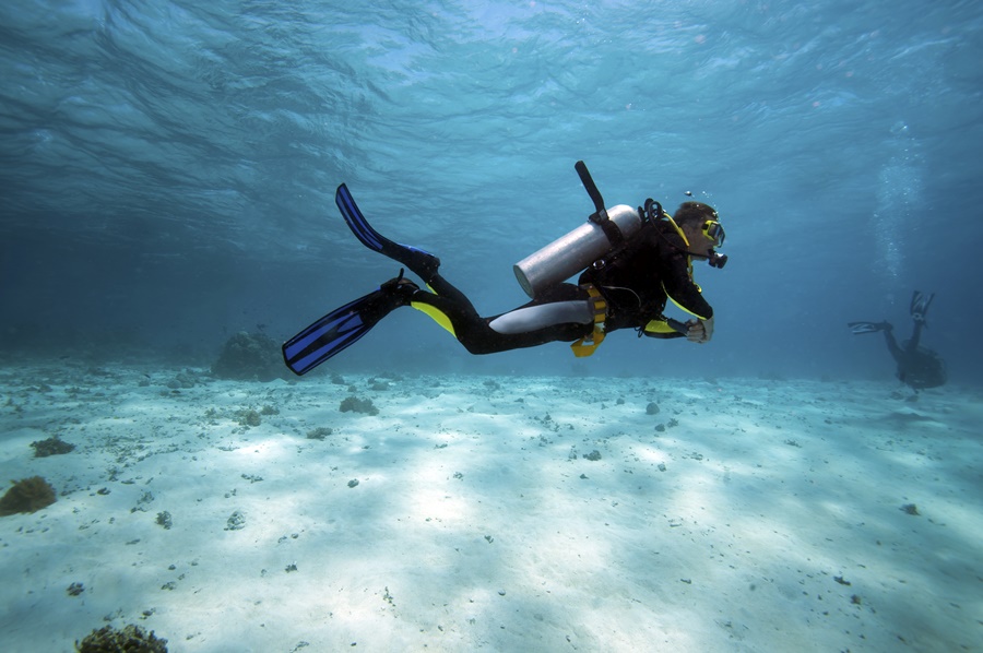 homem mergulhando no fundo do mar com roupa de mergulho destinos para se inspirar
