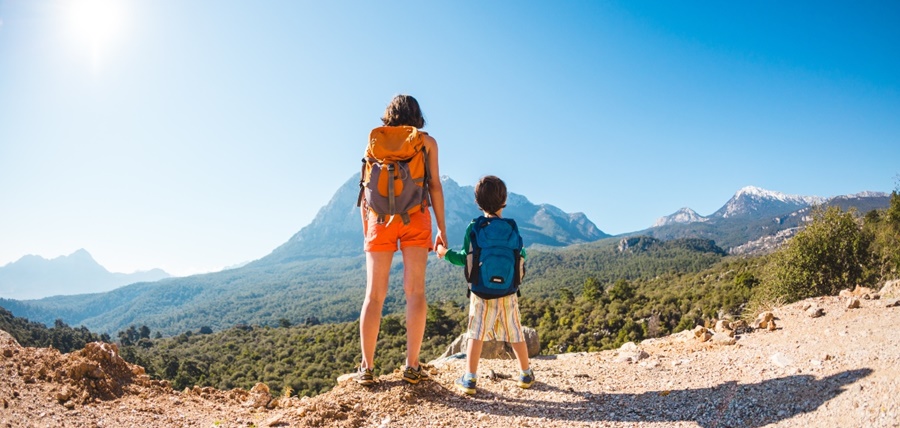 Mãe e filho fazendo trilha com mochila nas costas observando a paisagem Chile com crianças