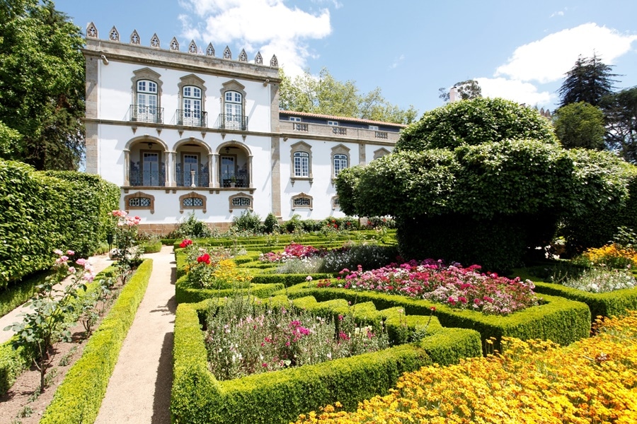 Fachada do castelo branco com jardim colorido a frente bem cuidado hotéis para casar em portugal