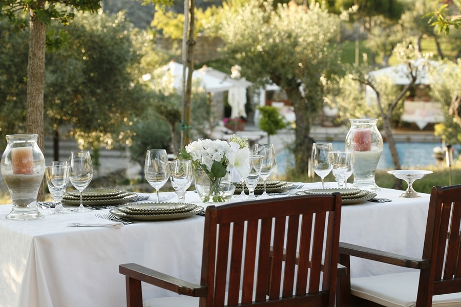 Mesa decorada para receber o evento de casamento com copos, pratos, velas e flores hotéis para casar em portugal