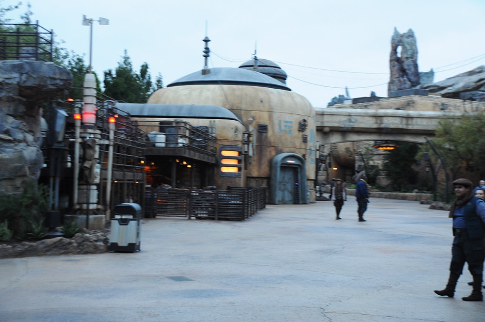 Droide a esquerda e homens encenando Disneyland