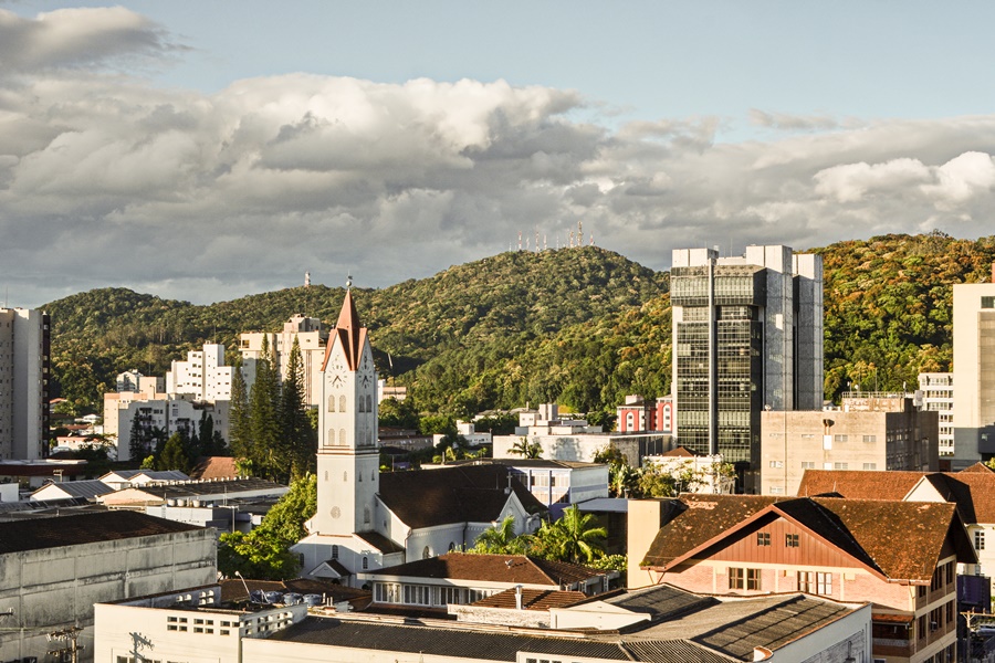Vista do alto da cidade de Joinville com prédios, casas e montanhas ao fundo destinos brasileiros mais baratos