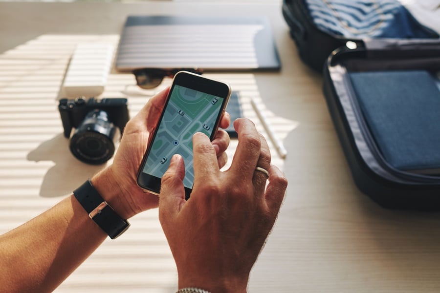 Pessoa com o celular na mão utilizando o GPS como usar celular no exterior