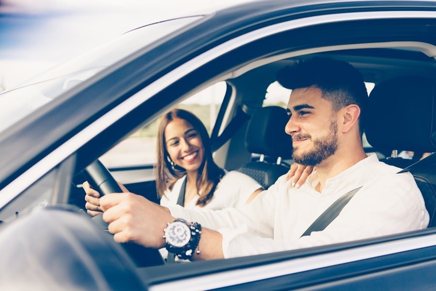 homem e mulher dentro do carro preto Alugar um carro na Rentcars
