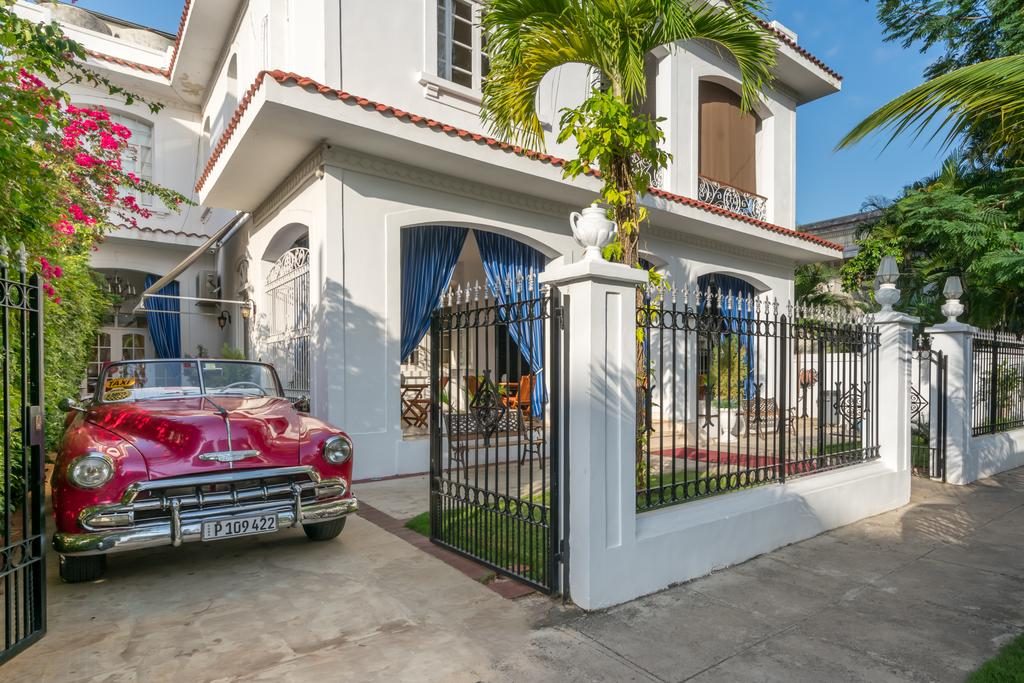 A fachada do El Candil Boutique Hotel com um carro vermelho Natal e Réveillon no exterior