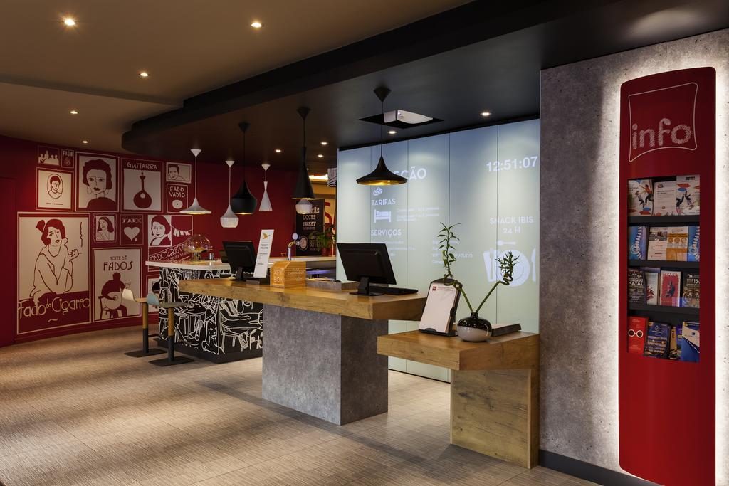 A recepção do hotel ibis Lisboa Liberdade, com avisos, luzes, computador e bancada Onde ficar em Lisboa