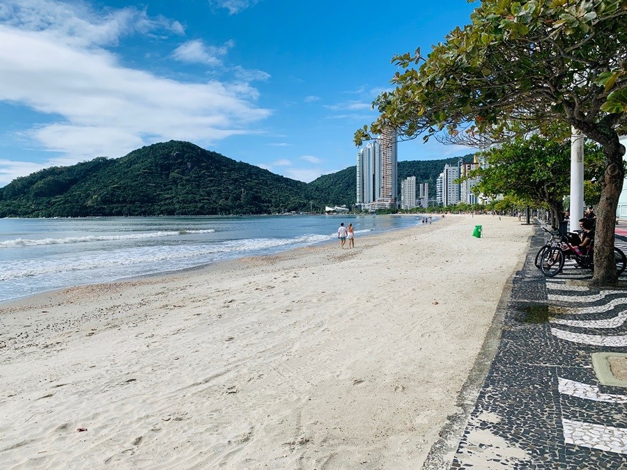 Praia de Balneário Camboriú com areia clara, montanha e mar azul