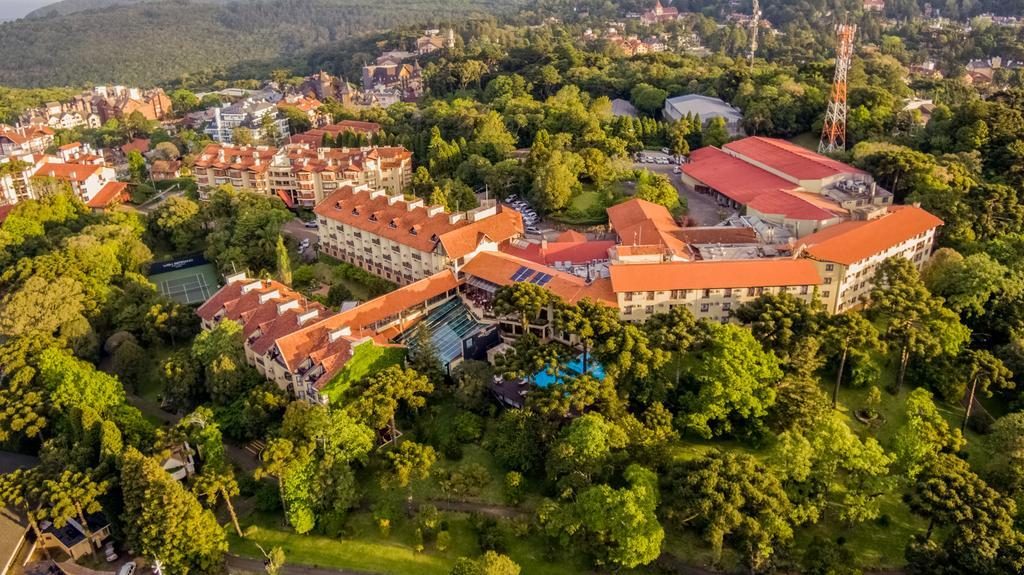 Vista aérea do Wish Serrano, em Gramado, com diversos prédios cercados de área verde Hotéis e resorts para férias